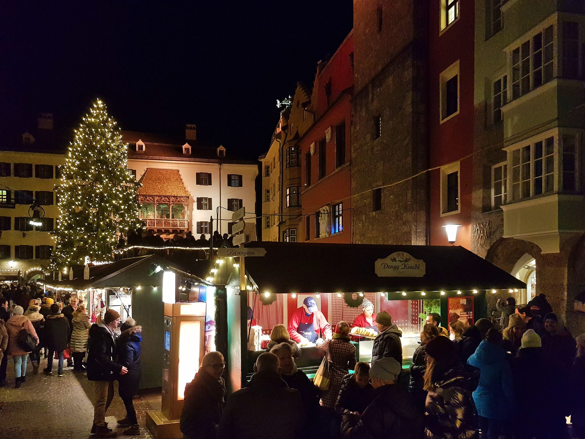 Beleuchtete Stände des Christkindlmarkts in der Innsbrucker Altstadt am Abend, dahinter das Goldene Dachl