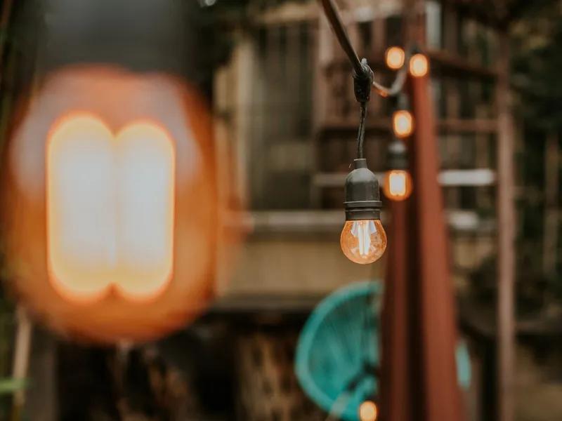 Lichterkette mit großen birnenförmigen Leuchtkörpern, die über einem Hof hängt