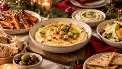 Festliche Wintertafel mit Hummus, gerösteten Karotten und Brot